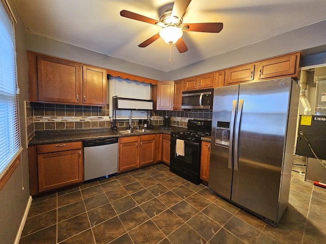 kitchen with appliances with stainless steel finishes, tasteful backsplash, ceiling fan, and sink