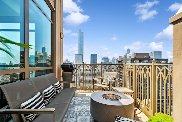 balcony with a grill and an outdoor living space with a fire pit