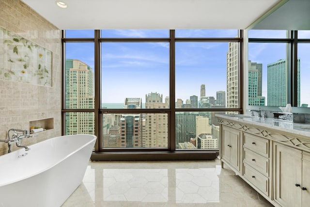 bathroom featuring a washtub, a wall of windows, tile walls, and vanity