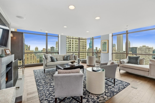 living room featuring light hardwood / wood-style flooring, expansive windows, and plenty of natural light