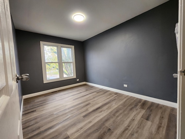 spare room with wood-type flooring