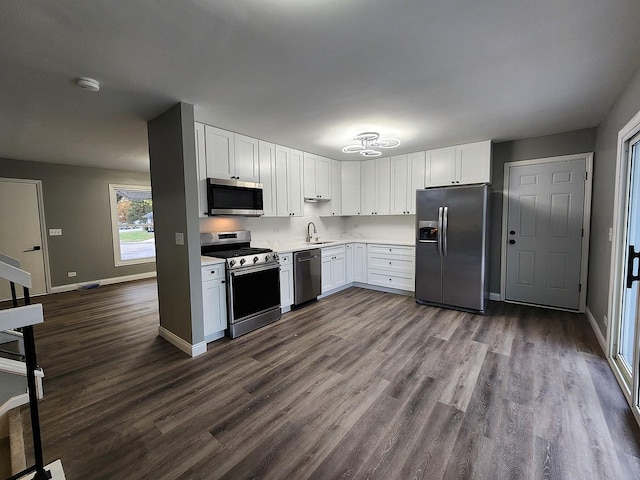 kitchen with hardwood / wood-style floors, stainless steel appliances, white cabinetry, and sink