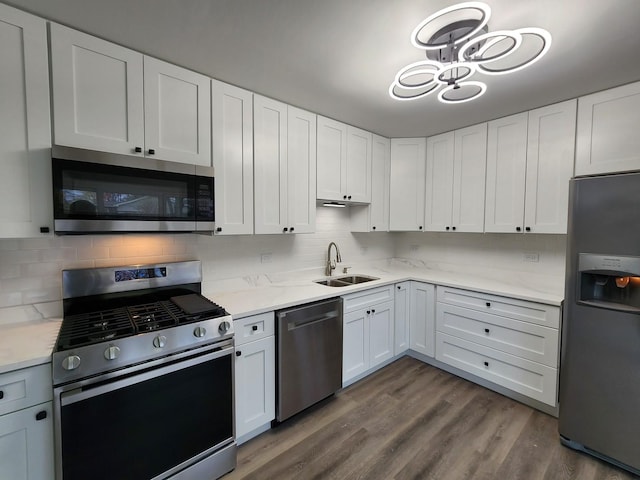 kitchen featuring sink, dark wood-type flooring, backsplash, white cabinets, and appliances with stainless steel finishes