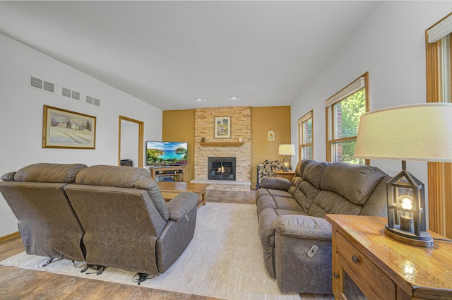 living room featuring light wood-type flooring and a stone fireplace