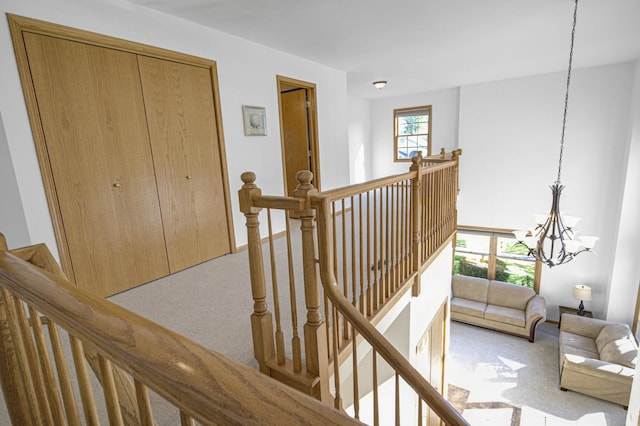 stairway featuring carpet floors and an inviting chandelier