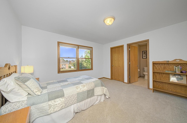 bedroom featuring ensuite bathroom and light carpet