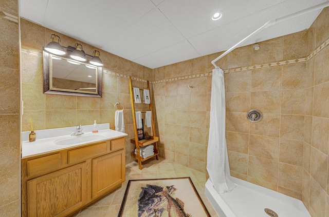 bathroom with vanity, tile patterned floors, walk in shower, and tile walls