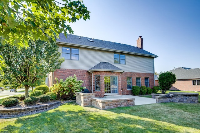 rear view of property with a lawn and a patio