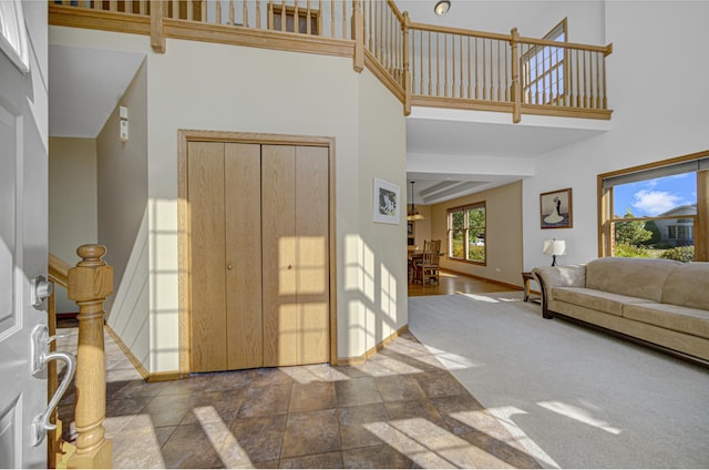 carpeted entrance foyer featuring a high ceiling