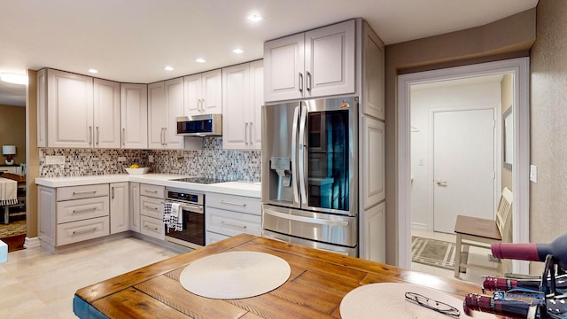 kitchen featuring backsplash, stainless steel appliances, and gray cabinetry