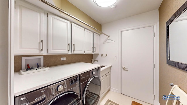 laundry area with cabinets, light tile patterned floors, sink, and washing machine and clothes dryer