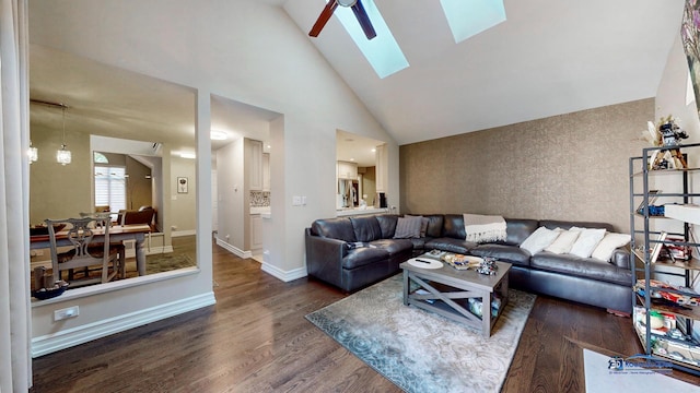 living room featuring dark hardwood / wood-style floors, ceiling fan, high vaulted ceiling, and a skylight