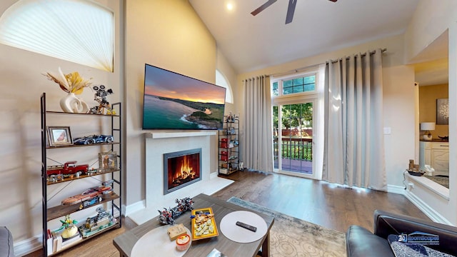 living room featuring hardwood / wood-style flooring, ceiling fan, and vaulted ceiling