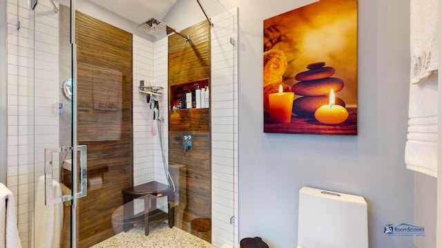 bathroom featuring toilet and a shower with shower door