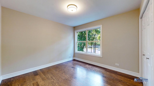 unfurnished bedroom with dark hardwood / wood-style flooring and a closet