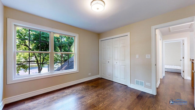 unfurnished bedroom featuring dark hardwood / wood-style flooring and a closet