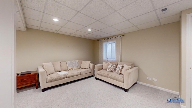 living room featuring light carpet and a drop ceiling