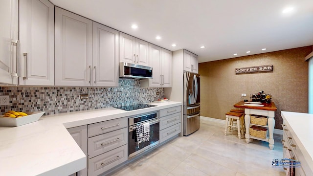 kitchen with appliances with stainless steel finishes, tasteful backsplash, and light tile patterned flooring