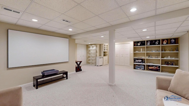 home theater room featuring carpet flooring, a paneled ceiling, and built in features