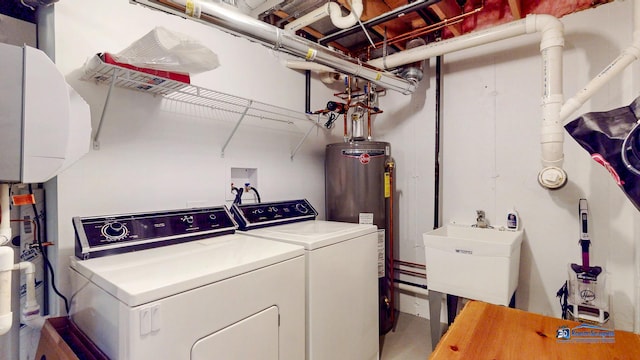 laundry area featuring gas water heater, separate washer and dryer, and sink