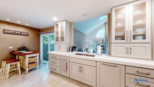 kitchen featuring light tile patterned floors, sink, and vaulted ceiling