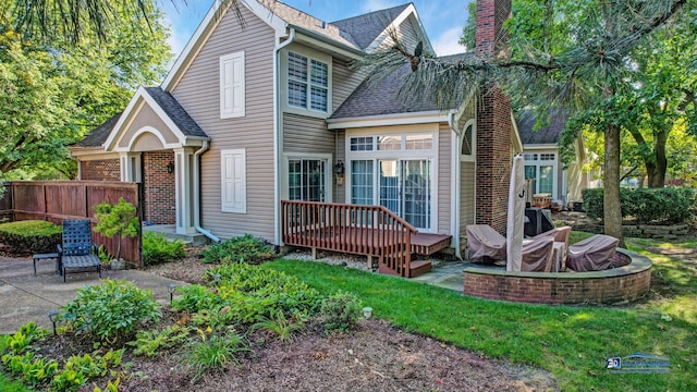 rear view of property featuring a patio area and a wooden deck