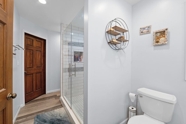 bathroom featuring toilet, wood-type flooring, and walk in shower