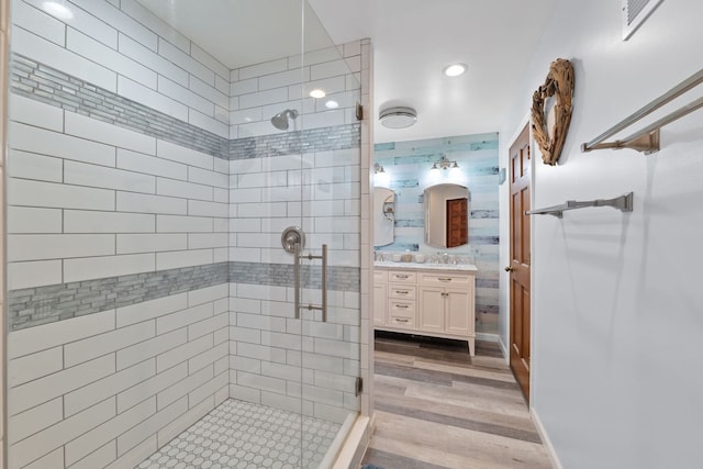 bathroom with vanity, a shower with door, and wood-type flooring