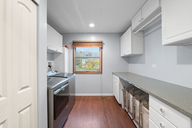 kitchen with dark hardwood / wood-style floors, independent washer and dryer, and white cabinets