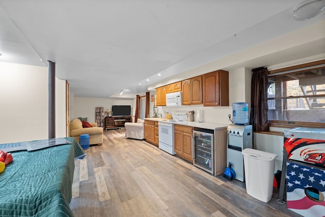 kitchen featuring wine cooler, white appliances, and light hardwood / wood-style flooring