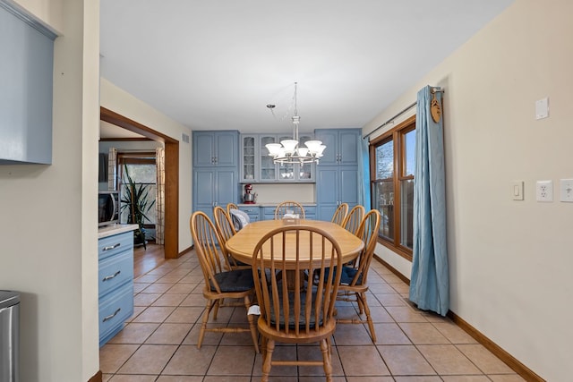 dining room with light tile patterned flooring and an inviting chandelier