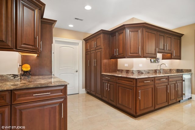 kitchen featuring stone countertops and dishwasher