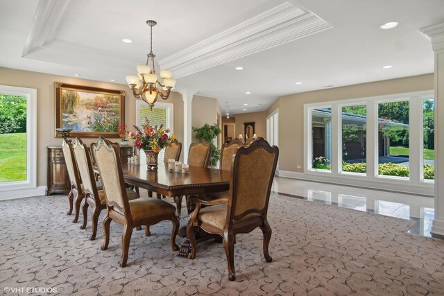 dining room with a chandelier, a tray ceiling, ornate columns, and ornamental molding