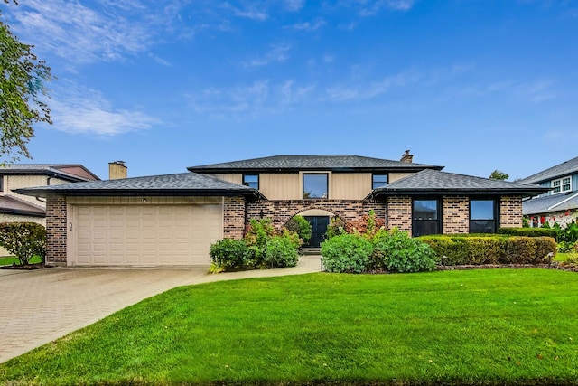 view of front of home with a front yard and a garage