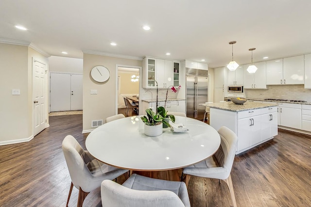 dining room with dark hardwood / wood-style flooring and crown molding