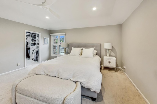 carpeted bedroom with a walk in closet, a closet, and ceiling fan