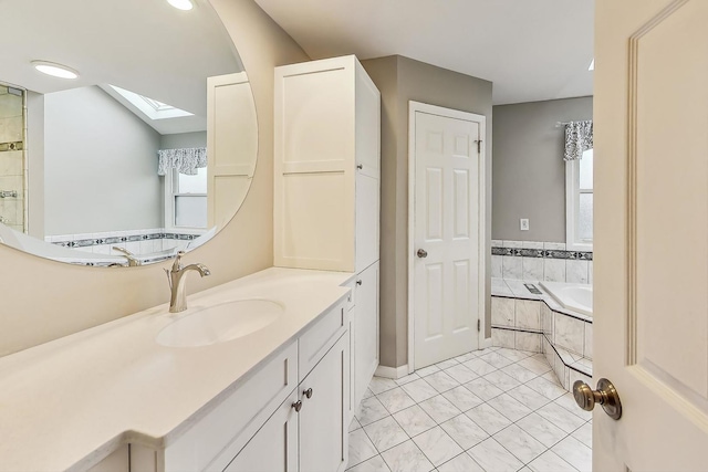 bathroom with tile patterned floors, a skylight, plenty of natural light, and vanity