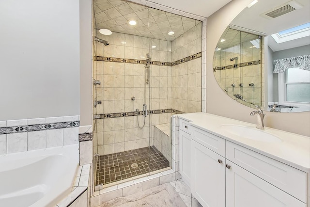 bathroom with a skylight, vanity, and independent shower and bath