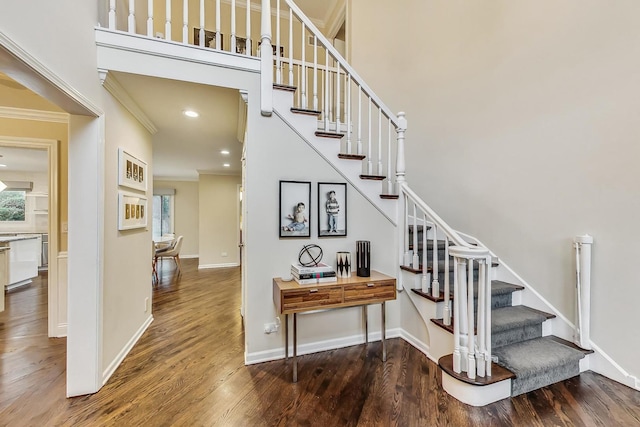 staircase with hardwood / wood-style flooring and ornamental molding