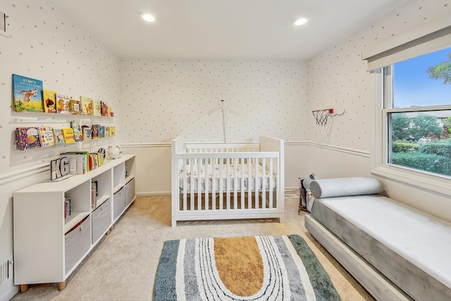 bedroom with a crib and light carpet