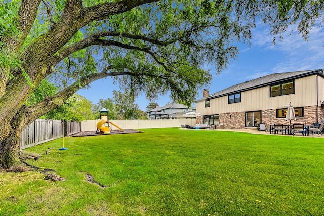 view of yard with a playground and a patio area