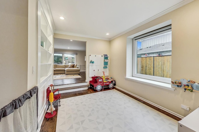 recreation room with hardwood / wood-style floors and crown molding