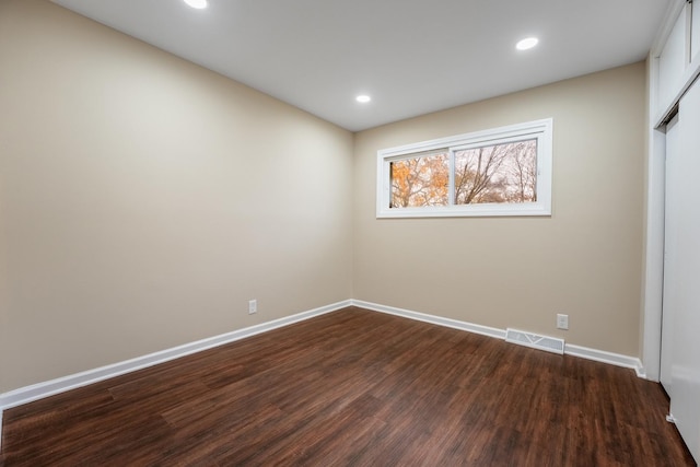 unfurnished room with dark hardwood / wood-style flooring