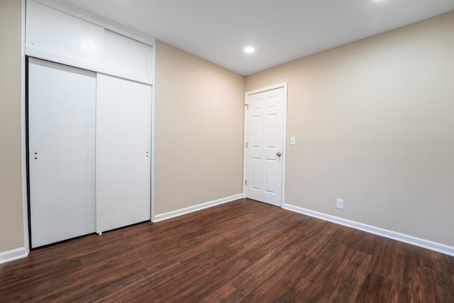 unfurnished bedroom featuring dark hardwood / wood-style floors and a closet