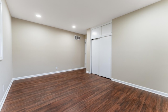 unfurnished bedroom with dark hardwood / wood-style floors and a closet