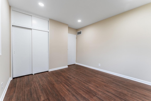 unfurnished bedroom featuring dark wood-type flooring and a closet