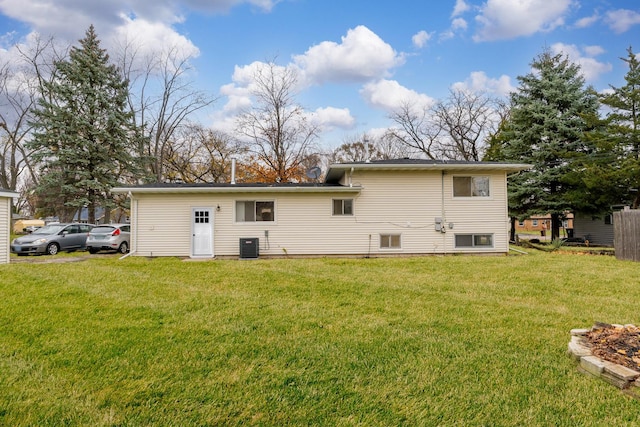 rear view of house with a lawn and central AC