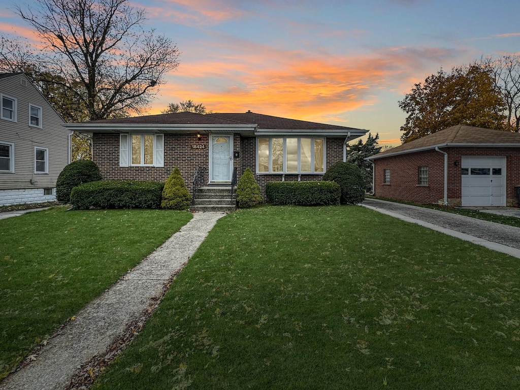 view of front of home featuring an outbuilding, a garage, and a lawn