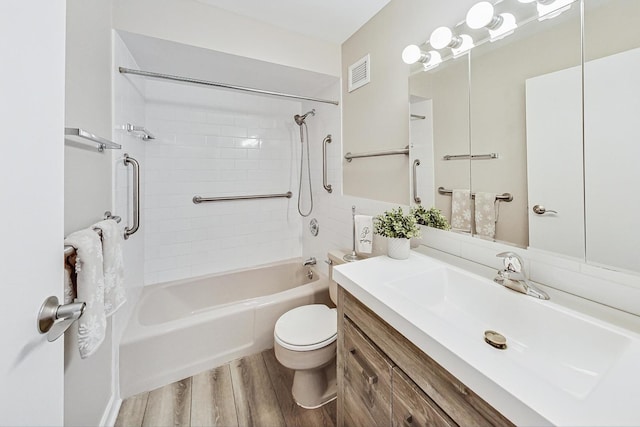 full bathroom featuring hardwood / wood-style flooring, vanity, toilet, and tiled shower / bath