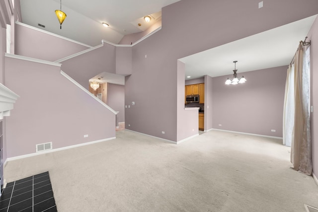 unfurnished living room featuring carpet floors, lofted ceiling, and an inviting chandelier